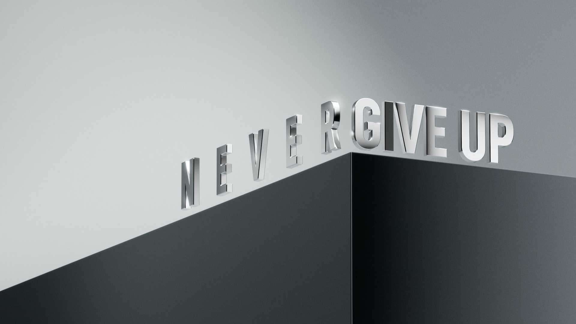 silver 3d letters that spell never give up going up a gray ramp